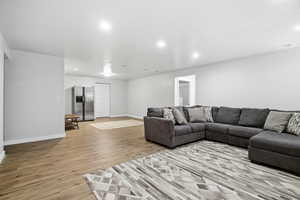 Living room featuring light wood-type flooring and recessed lighting.  Future kitchen potential in the back.