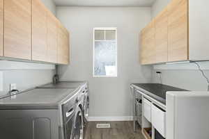 Laundry area with cabinet space, washer and dryer, and dark wood-style flooring