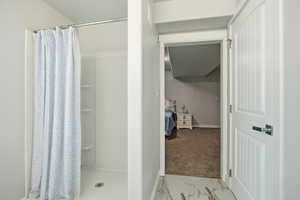 Bathroom with light marble finish floors, a shower stall, and ensuite bath