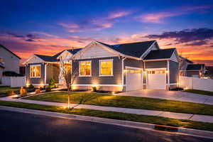 AI Enhanced Twilight. View of front of home featuring driveway, a garage, and roof with shingles