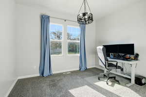 Office/bedroom featuring carpet and a chandelier