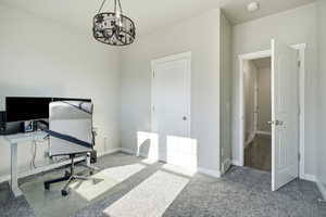 Office/bedroom area featuring carpet flooring and a chandelier