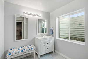 Bathroom featuring vanity and light marble finish flooring