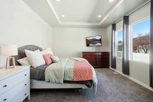 Bedroom with a tray ceiling, carpet floors, and recessed lighting