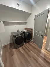 Laundry area featuring light wood-style floors and washer and dryer
