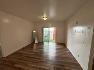 Unfurnished room featuring dark wood finished floors and a textured ceiling