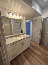 Bathroom featuring a textured ceiling, vanity, dark wood-style floors, and curtained shower