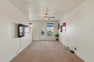 Spare room featuring carpet floors, a ceiling fan, and a smoke detector
