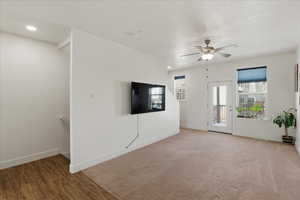 Unfurnished living room with a ceiling fan and wood finished floors