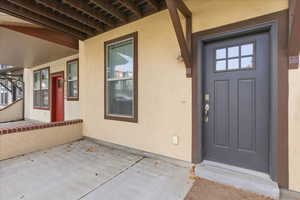 Property entrance featuring stucco siding and a patio