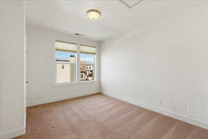 Empty room featuring light colored carpet and baseboards