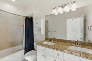 Bathroom featuring double vanity and shower / bath combo