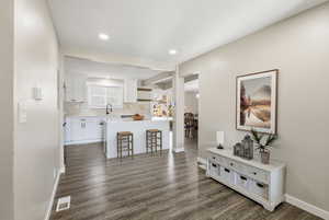 Hallway featuring dark wood-style floors and baseboards
