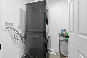 Laundry room featuring stacked washer and clothes dryer & a separate large farm sink.