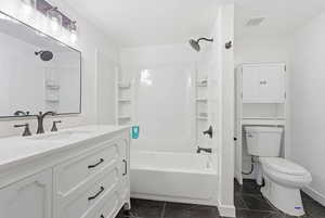 Bathroom with tub / shower combination, large vanity, dark marble finish flooring, and this is adjacent to your own master suite.