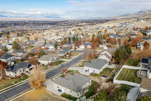 Aerial view of property and surrounding area featuring nearby suburban area and a mountain backdrop