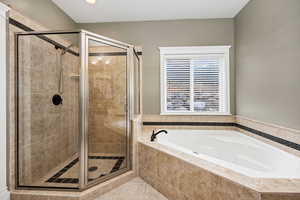 Full bathroom featuring a bath and a shower stall