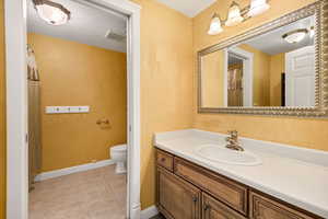 Bathroom with a shower with curtain, vanity, and light tile patterned flooring