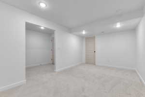 Basement with recessed lighting and light carpet