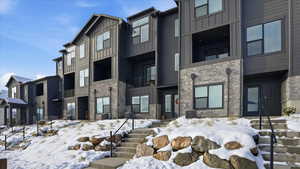 Snow covered property with a view of apartment building / complex