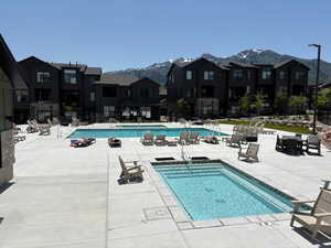 Community pool with a patio area and a mountain view