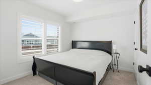Bedroom with light colored carpet and baseboards