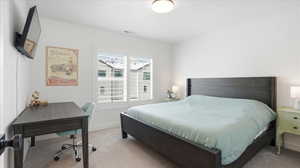 Bedroom with carpet floors and an office area