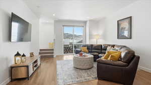 Living room featuring stairs, light wood-style floors, and recessed lighting