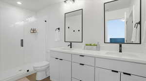Full bath featuring double vanity, a shower stall, and dark wood-style floors