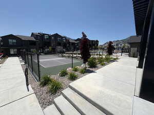 View of tennis court with a residential view
