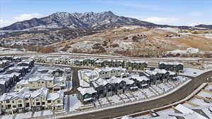 Snowy aerial view featuring a mountain view and a residential view