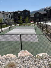 View of tennis court with a residential view and a mountain view