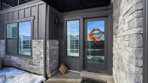 Property entrance with stone siding and board and batten siding