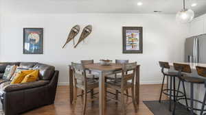 Dining room with dark wood finished floors and recessed lighting