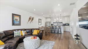 Living room with light wood-style flooring and recessed lighting