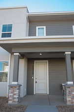 Entrance to property with stucco siding and a porch