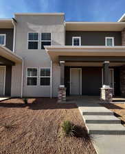 View of front facade featuring stucco siding and covered porch