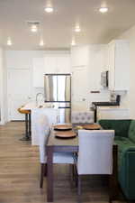 Dining space with light wood-style floors and recessed lighting