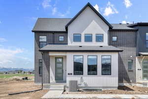 View of front of house with a shingled roof, brick siding, and a mountain view
