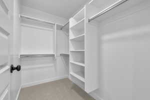 Spacious closet with light colored carpet
