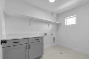 Laundry area featuring hookup for a washing machine, hookup for an electric dryer, and cabinet space