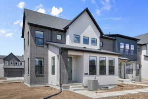 View of front of house featuring brick siding and a shingled roof