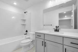 Bathroom featuring tub / shower combination, vanity, and recessed lighting