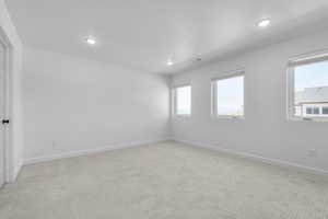 Spare room featuring carpet flooring and baseboards