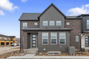 View of front of property with roof with shingles and brick siding