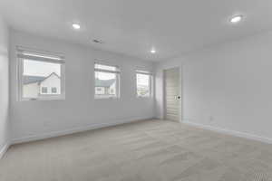 Carpeted empty room with baseboards and recessed lighting