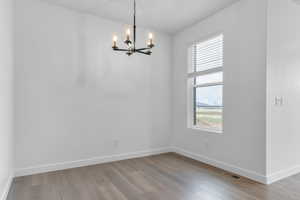 Unfurnished dining area with light wood-style flooring and a chandelier