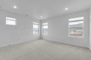 Carpeted spare room with healthy amount of natural light, recessed lighting, and a textured ceiling