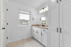 Bathroom featuring vanity, healthy amount of natural light, and light tile patterned floors