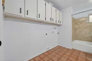 Laundry area featuring light floors, hookup for a washing machine, hookup for an electric dryer, and gas dryer hookup